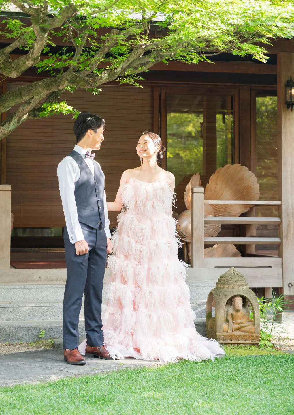 緑豊かな庭の前に並ぶ新郎新婦の後ろ姿