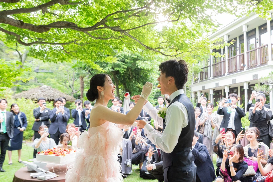 屋外の披露宴会場で新郎新婦とゲストが笑顔で過ごしている様子