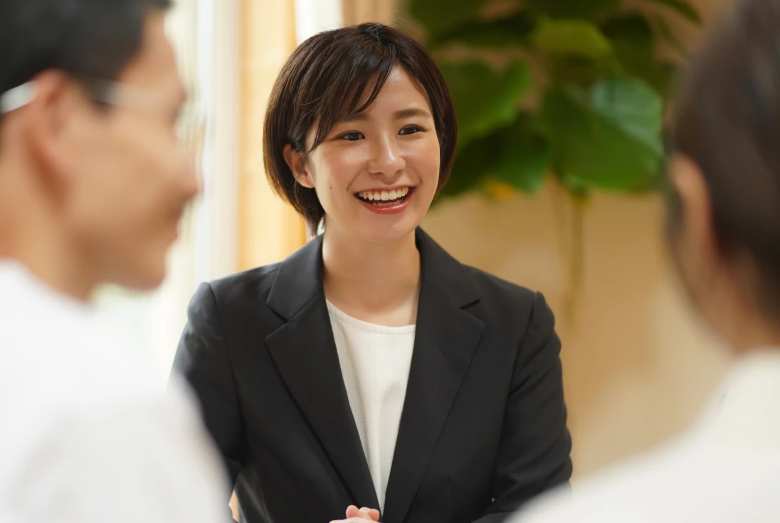 笑顔で会話するビジネススーツ姿の女性