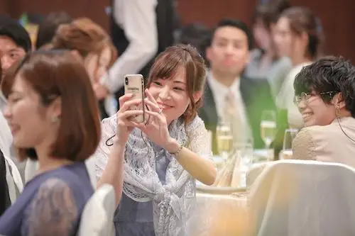 スマフォを使ってふたりを撮影するゲスト